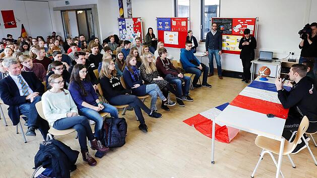 Fragen und Antworten in der KHG-Mensa mit den Sch&uuml;lern, Fabien Causeur (r.), Schulleiter Michael Strehler (zweite Reihe, l.) und Studienrat Christian Winkler (vor der Stellwand). Fotos: Daniel L&ouml;b
