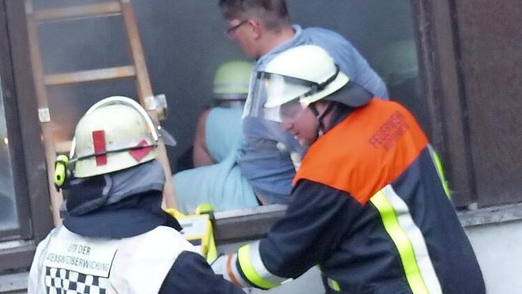 Die Feuerwehrleute bringen einen Verletzten durch ein Fenster in Sicherheit. Foto: Klaus-Peter Wulf