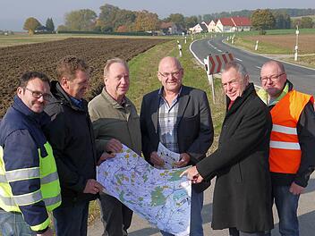 Die Pläne sind gemacht: Zwischen Herreth (hinten) und der Zigeunerlinde wird nicht nur die Staatsstraße 2204 erneuert, sondern auch mit einem Wirtschaftsweg ergänzt. Wie das geschehen soll, beraten (von links) Timo Sommerluksch (Landratsamt Coburg), Harald Schnappauf, Werner Thomas, Dieter Scherbel (Gemeinde Itzgrund), Jürgen Woll und Wolfgang Müller (Staatliches Bauamt). Foto: Berthold Köhler