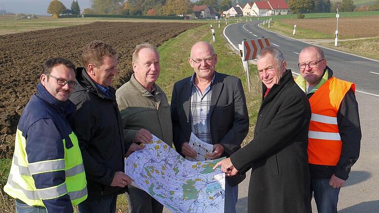 Die Pläne sind gemacht: Zwischen Herreth (hinten) und der Zigeunerlinde wird nicht nur die Staatsstraße 2204 erneuert, sondern auch mit einem Wirtschaftsweg ergänzt. Wie das geschehen soll, beraten (von links) Timo Sommerluksch (Landratsamt Coburg), Harald Schnappauf, Werner Thomas, Dieter Scherbel (Gemeinde Itzgrund), Jürgen Woll und Wolfgang Müller (Staatliches Bauamt). Foto: Berthold Köhler