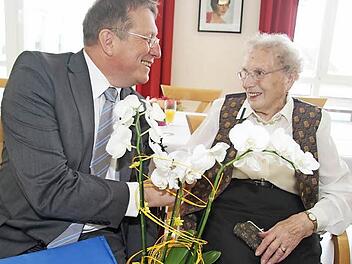 Charmant: Oberbürgermeister Henry Schrammt hatte für die hundertjährige Jubilarin eine weiße Orchidee mitgebracht. Ilse Schön freute sich auch über die Medaille des Ministerpräsidenten. Foto: Sonja Adam