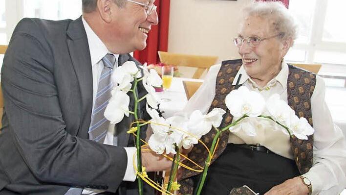 Charmant: Oberbürgermeister Henry Schrammt hatte für die hundertjährige Jubilarin eine weiße Orchidee mitgebracht. Ilse Schön freute sich auch über die Medaille des Ministerpräsidenten. Foto: Sonja Adam