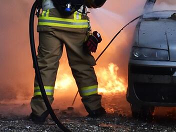Fahrzeugbrand, Autobrand, brennendes Auto, Feuerwehr löscht Flammen