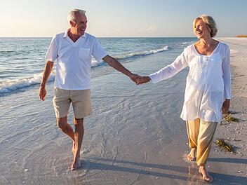 Happy Senior Couple Walking Holding Hands Tropical Beach