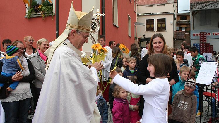 Die Kommunionkinder begrüßen den Erzbischof mit Blumen und Sternen