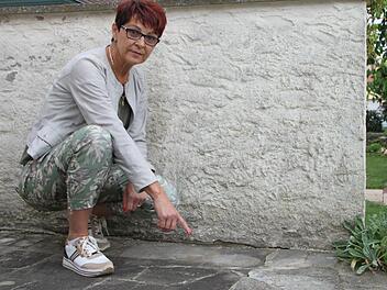 Karin Eyring zeigt auf die Platten, die sich in den letzten Monaten verschoben haben. Vorher gab es dort nie Probleme. Sie führt die Veränderungen auf Grundwasser zurück.