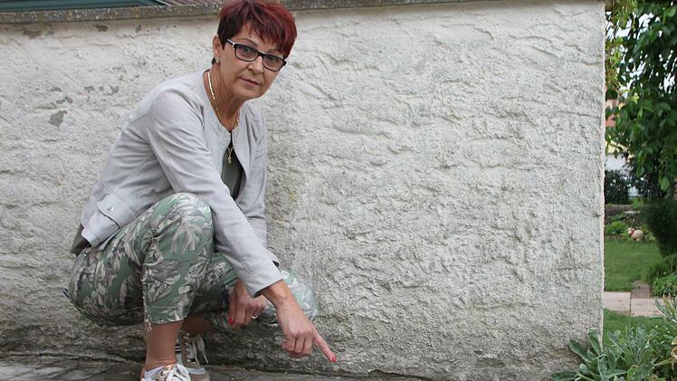 Karin Eyring zeigt auf die Platten, die sich in den letzten Monaten verschoben haben. Vorher gab es dort nie Probleme. Sie führt die Veränderungen auf Grundwasser zurück.