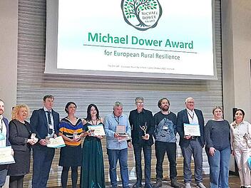 Projektmanagerin Kerstin Brückner (Sechste v. l.) und Gründungsvorsitzender Wolfgang Borst (Fünfter v. r.) zusammen mit weiteren Finalisten und Mitgliedern der Jury des Michael-Dower-Awards 2025.