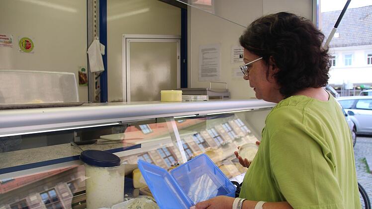 Jutta Wittmann holt sich ihren K&auml;se bei Direktvermarkter Michael Zeitz auf dem Rathausplatz. Foto: Benedikt Borst