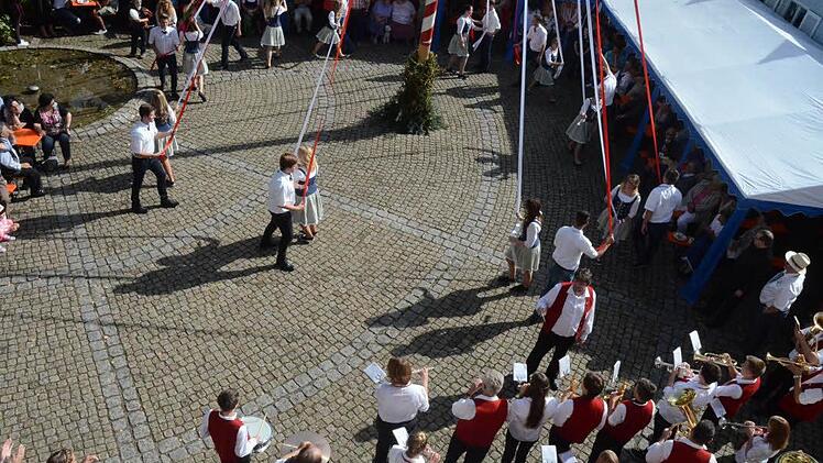 Der Bändertanz klappte wieder, obwohl diesmal elf neue Tanzpaare um den Kerwabaam das rot/weiße Geflecht in Diagonalen um den Baum zusammenbringen mussten.  Foto: Karl-Heinz Hofmann