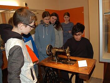 Abu Madaev (links) erläutert seinen Klassenkameraden aus der 7b, was es mit der Nähmaschine im Puppenmuseum auf sich hat. Rouzbeh Saffar darf sie gleich mal ausprobieren. Foto: Helke Renner