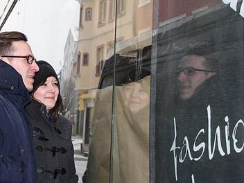 Neugierig: Jenny Striebel und Andreas Waldmann werfen durch ein kleines Loch im Papier einen Blick in die neue Tropics-Filiale. Foto: Ulrike Müller