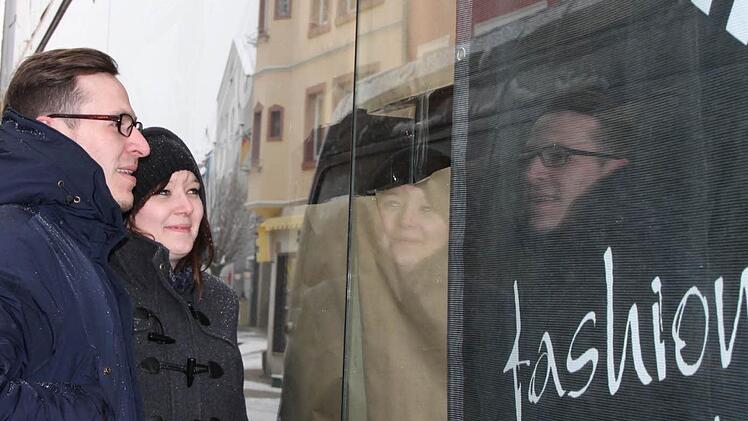 Neugierig: Jenny Striebel und Andreas Waldmann werfen durch ein kleines Loch im Papier einen Blick in die neue Tropics-Filiale. Foto: Ulrike Müller