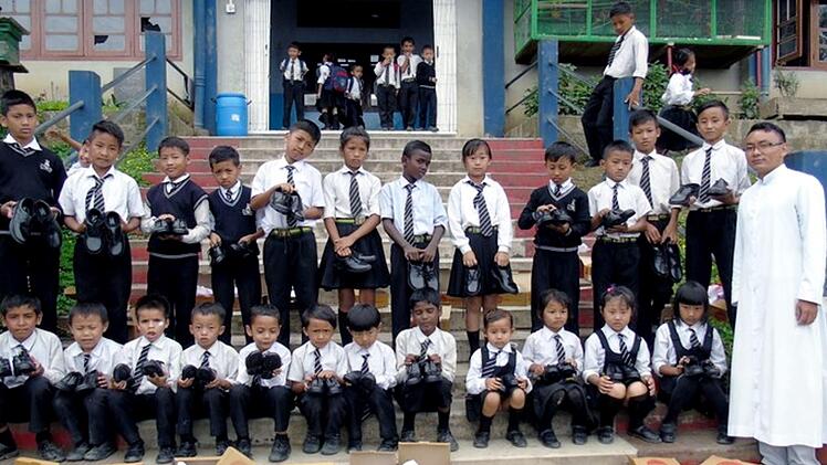 Mit Pater Samuel Elow präsentierten die Kinder ihre neuen Schuhe.      Foto: privat