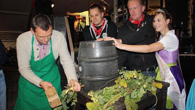 Bürgermeister Ludwig Wahl braucht zwei Schläge zum Bieranstich. Die Bierkönigin assistiert ihm.