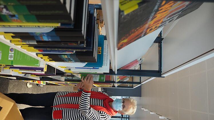 Mitarbeiterin Regine Blümig sortiert Bücher aus den Umzugskartons.