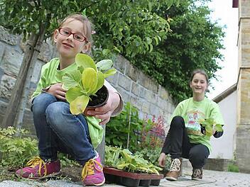 Stolz präsentiert Sina eines ihrer Lieblings-T-Shirts. Es weist sie als Kobold mit grünem Daumen aus. Zwischen Schlossmauer und Kirche haben die Kinder ein Beet, um welches sie sich mitkümmern. Foto: Markus Häggberg