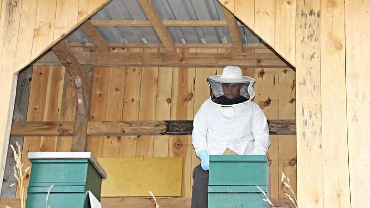 Jakob Groh in seinem Bienenhaus mit dem Equipement eines Imkers. Foto: Helmut Will