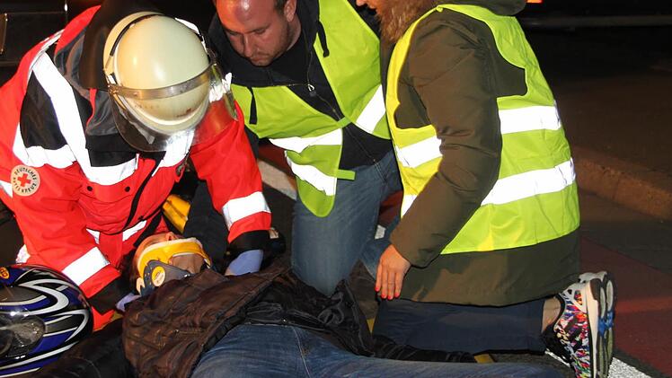 Erste-Hilfe-Maßnahmen,die bei der Motorradfahrerin vorgenommen werden.