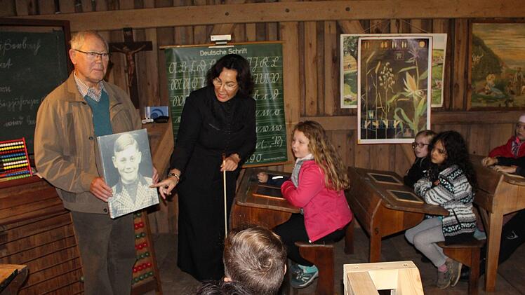 Der 82-jährige Anton Ebert aus Schondra erzählt aus seiner Schulzeit im Zweiten Weltkrieg. Schulfräulein Emilie führt die Kinder durch den historischen Unterricht. Foto: Julia Raab