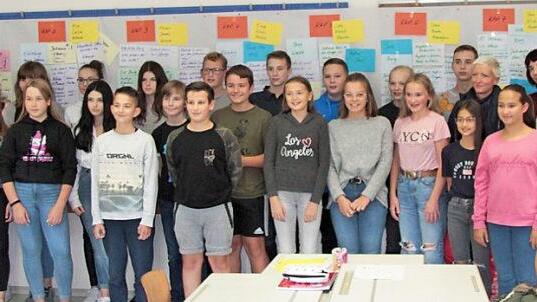 Schüler der Klasse 7 b mit Lehrern sowie zwei Rotarierinnen - im Hintergrund der Arbeitsplan bis zum fertigen Buch Foto: Jörg Hahn