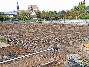 Während der Bauarbeiten bot das Reiterstadion der RSG Frankenhof ein wildes Bild. Mit Hartstein gefüllte Gabionen stabilisieren das Gelände zur Klosterkirche (im Hintergrund) hin.  Foto: Klaus Oelzner