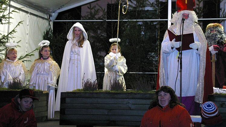 Begleitet von den drei Engelchen Johanna Hartan, Amelie Fischer und Ellena Bartsch (von links) hatte das neue Seßlacher Christkind Magdalena Autsch den ersten Auftritt. Später gesellten sich Nikolaus (Günther Dünisch) und Knecht Ruprecht (Kurt Knauer) dazu.