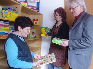 Der Außenstelle stehen zwei Zimmer für die heilpädagogische Förderung zur Verfügung. Im Bild (von links): Ursula John-Grafe, Frühförderstellen-Leiterin Elisabeth Naß sowie Lebenshilfe-Geschäftsführer Wolfgang Palm betrachten verschiedene Spiele. Foto: Heike Schülein
