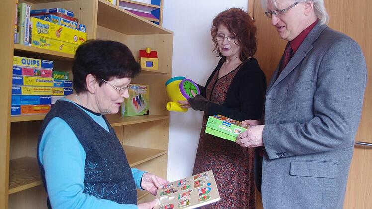 Der Außenstelle stehen zwei Zimmer für die heilpädagogische Förderung zur Verfügung. Im Bild (von links): Ursula John-Grafe, Frühförderstellen-Leiterin Elisabeth Naß sowie Lebenshilfe-Geschäftsführer Wolfgang Palm betrachten verschiedene Spiele. Foto: Heike Schülein