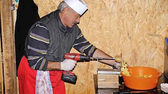 Mit einer Akkubohrmaschine und dem daran angeschlossenen Schneidegerät wurde die Spirale aus der ganzen Kartoffel hergestellt und dann auf dem Stand der Pfaffenhausener Musikkapelle frittiert. Foto: Gerd Schaar