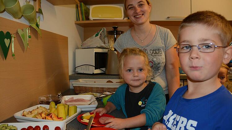 Melvin, Lenia und Andrea Gensler am neuen Buffet: Die Kinder können selbst entscheiden, was sie essen wollen, und sie können sich auch selber die Teller füllen. Foto: Elisabeth Assmann