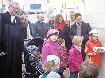 Die Schwestern Dahlia und Sidney Gatterfeld lassen zur Grundsteinlegung die Röhre im Mauerwerk verschwinden - für die Prominenz bleibt da nur die Zuschauerrolle. Hinten, von links: Pfarrer Rolf Gorny, Hans-Peter Hübner, Winfried Beyer, Kindergartenleiterin Sabine Tirsch, Roland Schultheiß und Martin Finzel.  Foto: Gabi Arnold