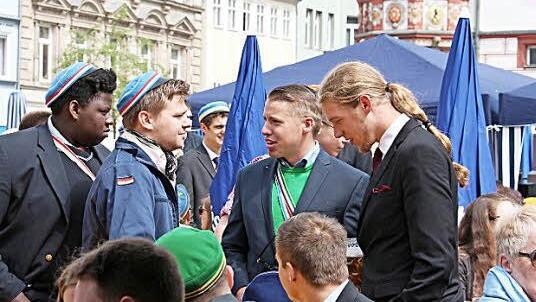 Die Studierenden mit Farbbändern und Mützen geben ein buntes Bild ab.