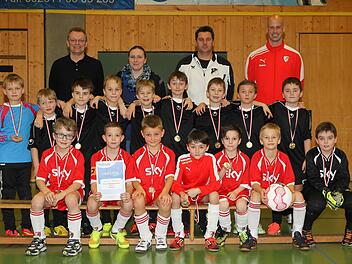 Der TSF Theisenort (schwarze Trikots) hat den Hallensparkassencup der F-Junioren vor dem FC Kronach (vorne) gewonnen. Mit im Bild (hinten von links): Robert Porzelt von der Sparkasse, Jugendspielgruppenleiterin Corinna Schmittlein sowie die Betreuer Tino Witzgall (Theisenort) und Christopher Schädla (Kronach). Fotos: Heinrich Weiß