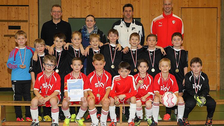Der TSF Theisenort (schwarze Trikots) hat den Hallensparkassencup der F-Junioren vor dem FC Kronach (vorne) gewonnen. Mit im Bild (hinten von links): Robert Porzelt von der Sparkasse, Jugendspielgruppenleiterin Corinna Schmittlein sowie die Betreuer Tino Witzgall (Theisenort) und Christopher Schädla (Kronach). Fotos: Heinrich Weiß