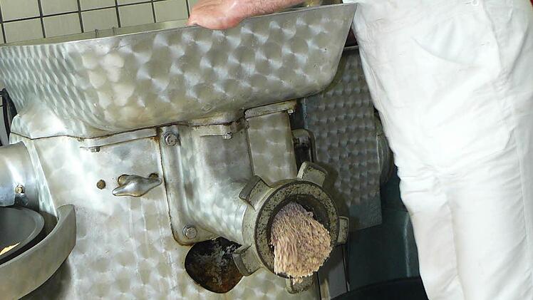 Metzgermeister Matthias Kummer zerkleinert Fleisch für den Presssack.