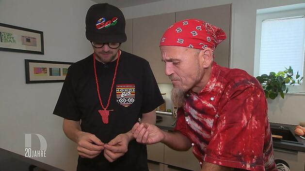 Ralf Zacherl (rechts) taucht &uuml;berraschend als Schnibbelhilfe bei Ees auf und probiert zum ersten Mal einen Mopanewurm.