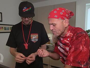 Ralf Zacherl (rechts) taucht &uuml;berraschend als Schnibbelhilfe bei Ees auf und probiert zum ersten Mal einen Mopanewurm.