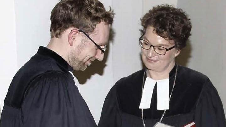 Dekanin Schürmann (M.) übergibt Michael Maul die Urkunde für die neue Pfarrstelle.  Foto: Löwisch