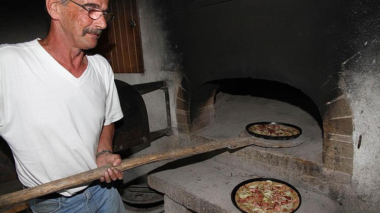 Die Aufgabe von Engelbert Mirsberger war es, die Zwiebelkuchen im Holzbackofen fertig zu machen. Foto: Erlwein