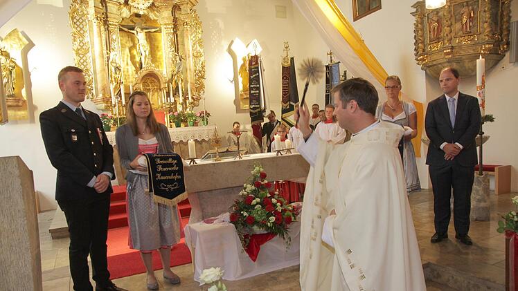 Pfarrer Matthias Steffel weiht die neuen Fahnenbänder. Foto: Mathias Erlwein