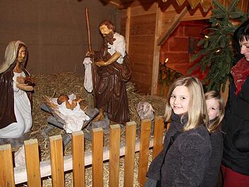 Die Krippe mit lebensgroßen Figuren faszinierte Sina und Dana , die  mit ihrer Mutter zum Adventsmarkt nach Eggolsheim gekommen waren. Foto: Mathias Erlwein