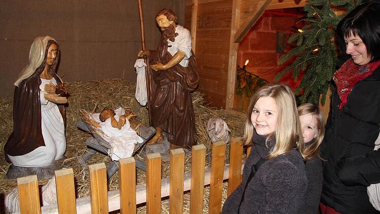 Die Krippe mit lebensgroßen Figuren faszinierte Sina und Dana , die  mit ihrer Mutter zum Adventsmarkt nach Eggolsheim gekommen waren. Foto: Mathias Erlwein
