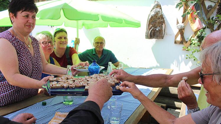 Geselliges Zugreifen - darum geht es bei den Genusswanderungen auch. Hier bietet Karin Schorn (l.) der hungrig gewanderten Gruppe Spezialitäten aus Roggen an.