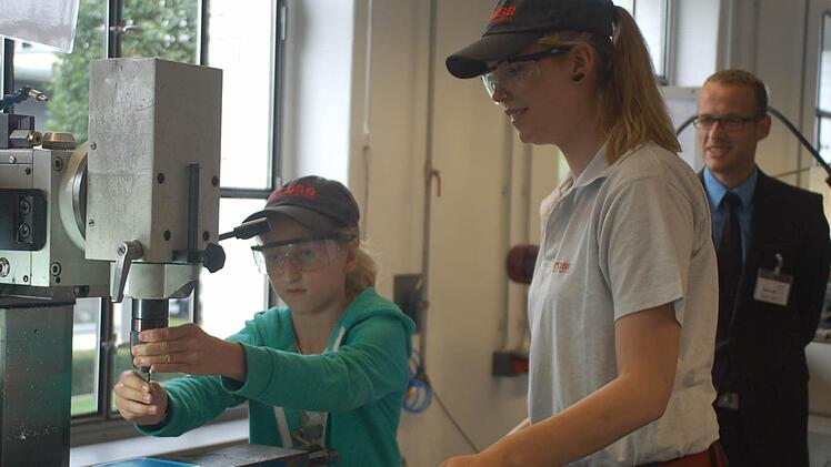 Eva Schug darf sogar an der Fräsmaschine Hand anlegen; die Brose-Auszubildende Sophie Escher passt auf und erklärt. Fotos: Gabi Arnold