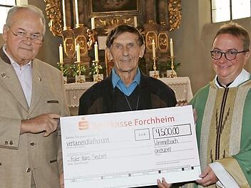 Kirchenpfleger Peter Gügel (l.) und Pfarrer Klaus Weigand überreichten Frater Hans Seubert (M.) einen Scheck.