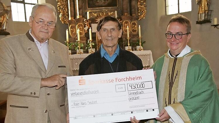 Kirchenpfleger Peter Gügel (l.) und Pfarrer Klaus Weigand überreichten Frater Hans Seubert (M.) einen Scheck.