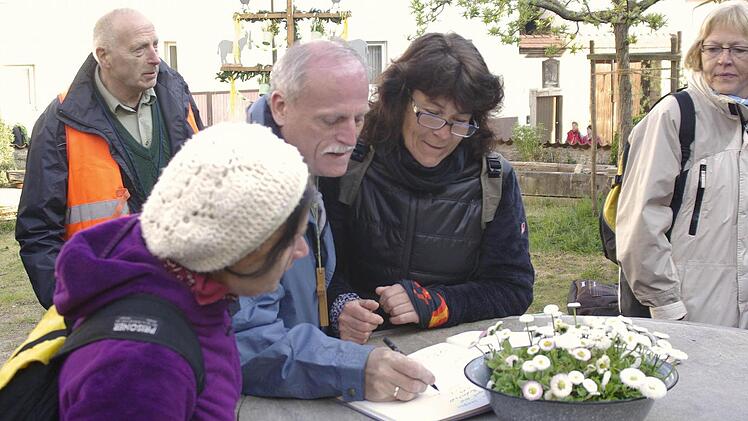 Stadtrat Arnold Eiben trägt sich bei der Morgenrast in Machtilshausen in das Gästebuch des "Schreinersch-Haus" ein. Foto: Ehling