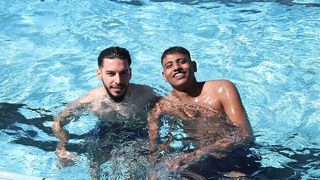 Hammoud Ehkhalaf (23) und Mohammad Faou (22) genie&szlig;en den Schwimmbadauftakt und finden es super, dass es keine Zugangsbeschr&auml;nkungen mehr gibt.