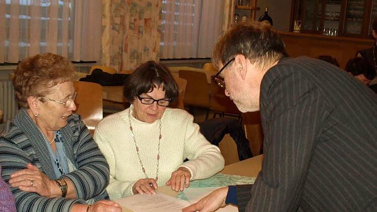 "Das ist gar nicht so leicht", scheint Hilde Lauterbach (links) zu sagen, als sie zusammen mit Marga Spranger die Aufgaben des Gehirnjoggings liest. Norbert Grundhöfer gibt dazu Erklärungen.